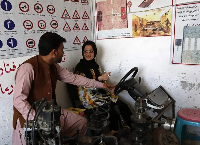 Tahmina, (R) talks to her instructor during a practical lesson at a driving school in Kabul September 4, 2014. (Photo by Mohammad Ismail/Reuters)