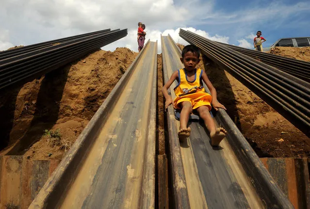 Children play on a metal beam in Manila on April 23, 2013. The Philippines has failed to make headway in cutting rampant poverty, with more than one in four citizens deemed poor despite the country's economic growth, according to census figures released Tuesday. The July 2012 poverty rate of 27.9 percent is practically unchanged from 2006 and 2009 data, according to the National Statistical Coordination Board. (Photo by Noel Celis/AFP Photo)