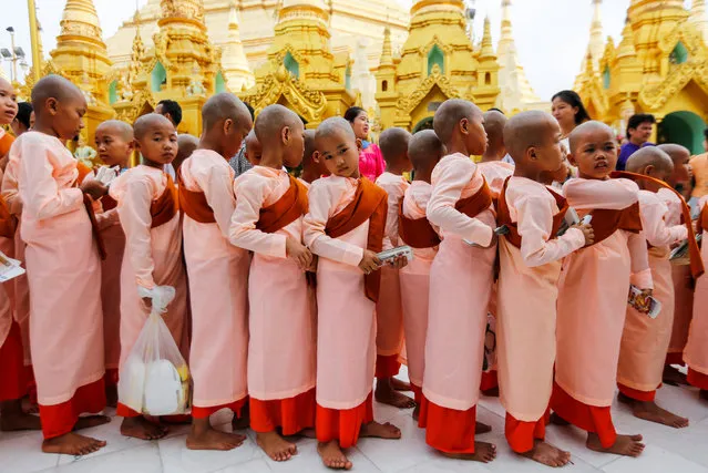 Young Buddhist nuns arrive to pray at the holy Shwedagon pagoda to mark the Myanmar New Year Day in Yangon, Myanmar, 17 April 2018. Myanmar people celebrate the New Year of the Burmese calendar, the year of 1379, by going to pagodas, donating food, freeing birds or fish and paying their respects to the elderly. (Photo by  Lynn Bo Bo/EPA/EFE)