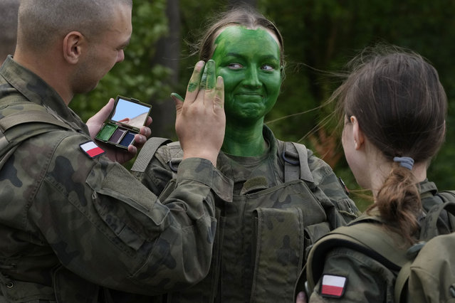 Volunteers in Poland's army learn to apply camouflage face paint during basic training in Nowogrod, Poland, on Thursday June 20, 2024. Poland’s army has launched a program this summer called “Holidays with the Army” to train young volunteers in combat. Nations along NATO’s eastern flank are strengthening their defenses while fearing that Russia could one day attack them if it prevails in neighboring Ukraine. (Photo by Czarek Sokolowski/AP Photo)