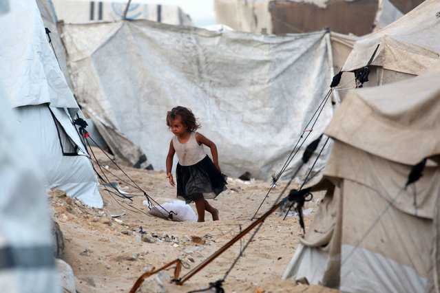 A displaced Palestinian child runs amid tents used as temporary shelter, in Deir el-Balah in the central Gaza Strip, on October 5, 2025. Negotiators were converging on Cairo on October 5 ahead of talks aimed at ending nearly two years of war in Gaza, with Israel's leader expressing hope that the hostages still being held there would be released in a matter of days. (Photo by Bashar Taleb/AFP Photo)