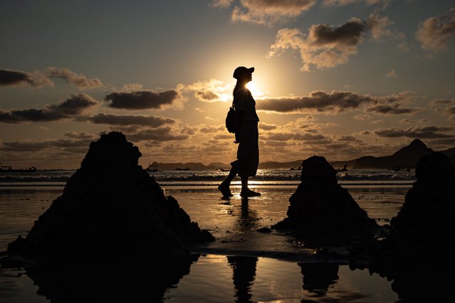 Tourists enjoy sunset at Selong Belanak beach on October 07, 2025 in Lombok, Indonesia. Lombok's tourism industry is booming as Indonesia's second most popular destination after Bali. (Photo by AFP Photo/Stringer)
