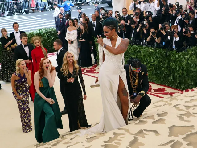 2 Chainz, kneeling center, and Kesha Ward, standing center, arrive at The Metropolitan Museum of Art's Costume Institute benefit gala celebrating the opening of the Heavenly Bodies: Fashion and the Catholic Imagination exhibition on Monday, May 7, 2018, in New York. (Photo by John Carucci/AP Photo)