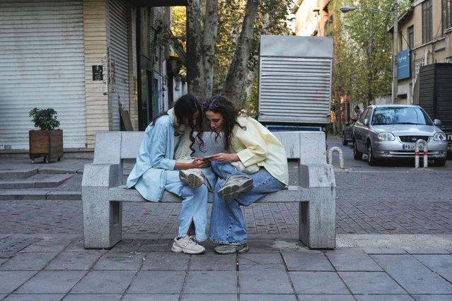 Two women use a smartphone in northern Tehran, Iran, Sunday, September 28, 2025. (Photo by Vahid Salemi/AP Photo)