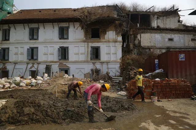 Nepalese men work on reconstruction of a site damaged by the 2015 earthquake at Basantapur Durbar square during the third anniversary of the earthquake in Kathmandu, Nepal, Wednesday, April 25, 2018. (Photo by Niranjan Shrestha/AP Photo)