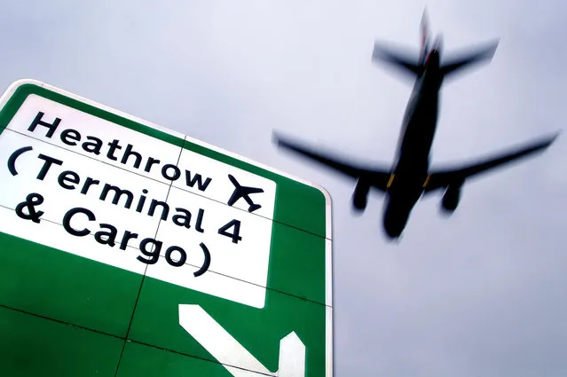 An aeroplane flying above road signs near Heathrow International Airport, London, England. (Photo by Alamy Stock Photo)