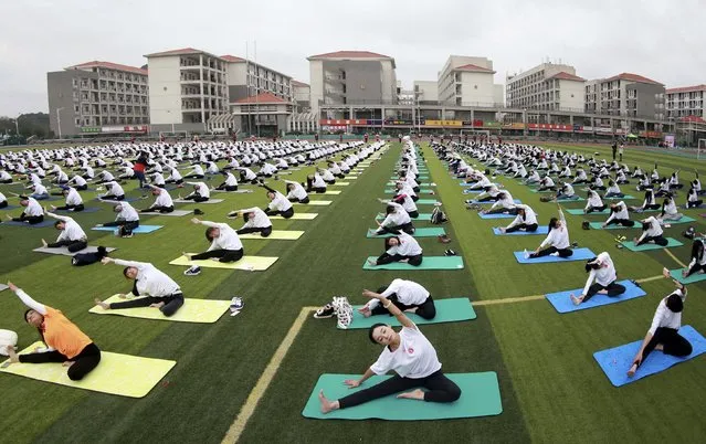 Hundreds of participants practice yoga at a charity event to mark the upcoming World AIDS Day, at an university in Guilin, Guangxi Zhuang Autonomous Region, China, November 29, 2015. (Photo by Reuters/Stringer)