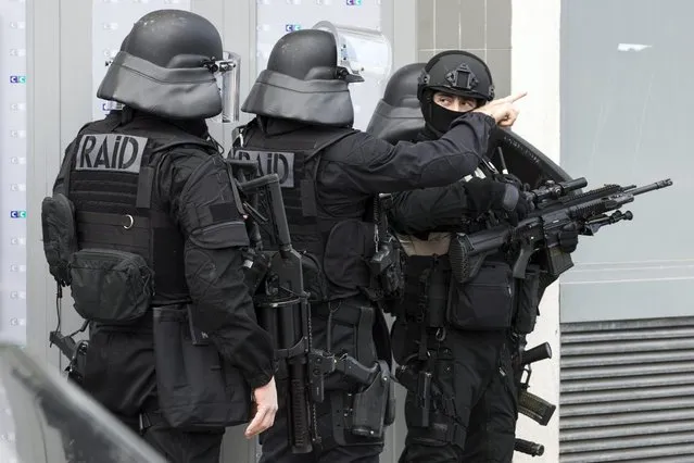 Police officers from the special RAID (Recherche, assistance, intervention, dissuasion) and BRI (Brigades de recherche et dintervention) units get ready as a hostage situation occurs in a post office in Colombes, in the North West of Paris, France, 16 January 2015. From recent news reports, a man entered the post office heavily armed shortly after noon and still holds two persons hostage. (Photo by Ian Langsdon/EPA)
