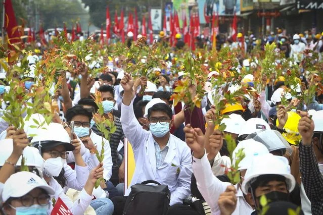 Students from the University of Medicine protest with brunches of Eugenia plants during an anti-coup protest in Mandalay, Myanmar, Sunday, February 21, 2021. Police in Myanmar shot dead a few anti-coup protesters and injured several others on Saturday, as security forces increased pressure on popular revolt against the military takeover. (Photo by AP Photo/Stringer)