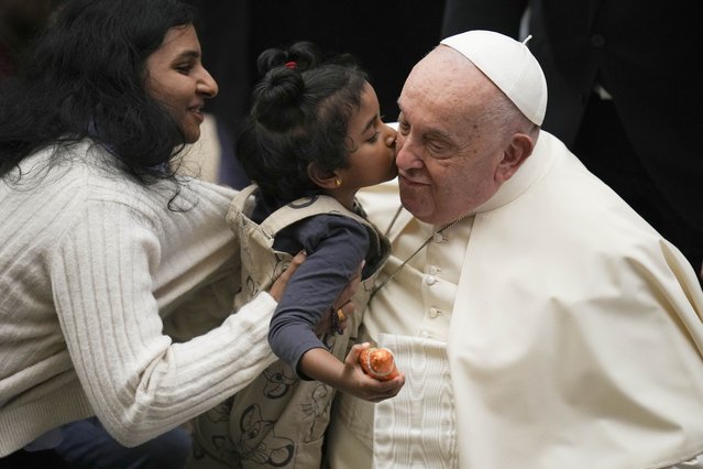 Pope Francis is kisses by a child during the weekly general audience at the Vatican, Wednesday, December 18, 2024. (Photo by Alessandra Tarantino/AP Photo)