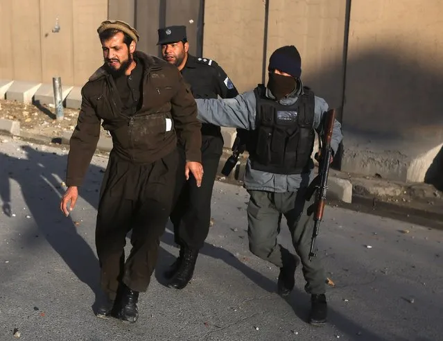 Police arrest an Afghan man throwing stones towards a U.S. compound during a demonstration against the satirical French weekly Charlie Hebdo's cartoons of the Prophet Mohammad, in Kabul, January 23, 2015. French satirical magazine Charlie Hebdo published a picture of the Prophet Mohammad weeping on its cover last week after gunmen stormed its offices in Paris, killing 12 people. (Photo by Omar Sobhani/Reuters)