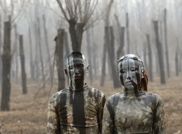 Models painted in camouflage colours to blend in with the background pose for Chinese artist Liu Bolin's artwork “Dongji”, or Winter Solstice, on the second day after China's capital Beijing issued its second ever “red alert” for air pollution, in Beijing, China, December 20, 2015. (Photo by Kim Kyung-Hoon/Reuters)