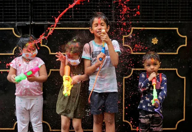Children react as they are splashed with coloured water during Holi celebrations, amidst the spread of the coronavirus disease (COVID-19), in Chennai, India, March 29, 2021. (Photo by P. Ravikumar/Reuters)