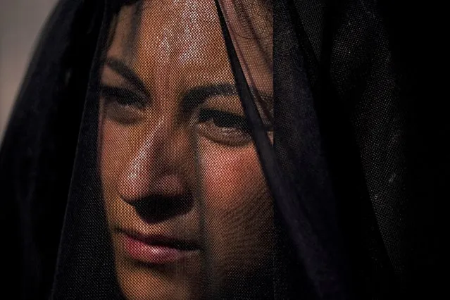 A demonstrator wearing a black veil attends a protest event coined a national mourning against femicides in the Zocalo of Mexico City, Wednesday, May 18, 2022. Other protesters carried red crosses that reads in Spanish “Justice!”. (Photo by Fernando Llano/AP Photo)