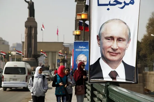 Girls walk past a banner with a picture of Russian President Vladimir Putin along a bridge, in central Cairo February 9, 2015. Putin is due to arrive on Monday on his first visit to Egypt in ten years. (Photo by Asmaa Waguih/Reuters)