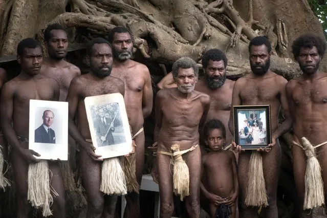 This picture taken on April 12, 2021 shows tribesmen holding portraits of Britain's Prince Philip in the town of Yaohnanen, near the town of Yakel, a remote Pacific village on the island of Tanna in Vanuatu that worships Britain's Prince Philip, following the Duke of Edinburgh's death on April 9. (Photo by Dan McGarry/AFP Photo)