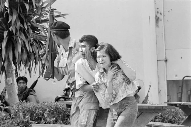 In this October 6, 1976, file photo, a leftist student, center, wounded and captured by police is helped to an ambulance during the student massacre at the Thammasat University campus in Bangkok, Thailand. This year’s anti-government protests are seeking new elections, a more democratic constitution and an end to intimidation of political activists. Their speeches have repeatedly highlighted the 1976 tragedy, piquing the interest of the current generation in what their forebears faced. (Photo by Neal Ulevich/AP Photo/File)