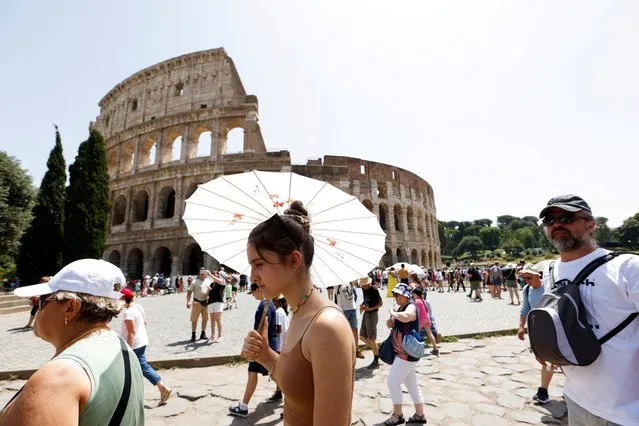 People walk near the Colosseum during a heat wave across Italy as temperatures are expected to rise further in the coming days, in Rome, Italy on July 17, 2023. (Photo by Remo Casilli/Reuters)
