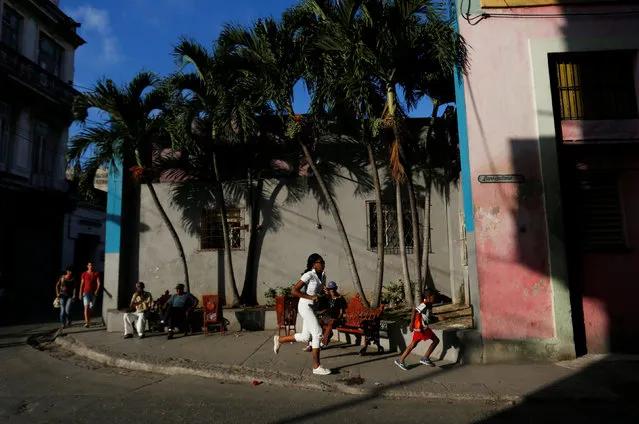 A woman and a child run on a sidewalk in Havana, Cuba, December 3, 2016. (Photo by Reuters/Stringer)
