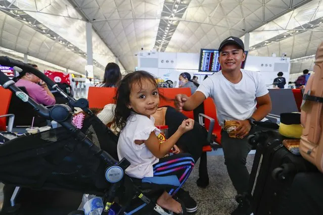 Filipino tourist Andres at right with his daughter wait for rescheduling after their flight returning to the Philippines was cancelled at the Hong Kong International Airport, in Hong Kong, on Friday, September 1, 2023. Hundreds of flights were cancelled as most of Hong Kong and other parts of southern China ground to a near standstill as Super Typhoon Saola edged closer Friday. (Phoot by Daniel Ceng/AP Photo)