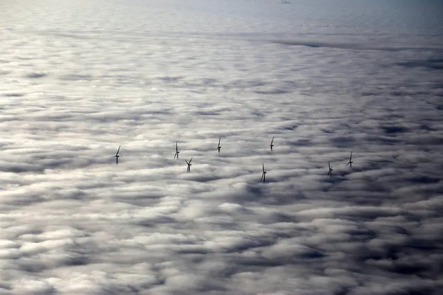 In this December 4, 2016 photo wind turbines stand out of the fog near Rotenburg, northern Germany. Large parts of northern Germany were under thick fog on Sunday. (Photo by Stefan Rampfel/DPA via AP Photo)