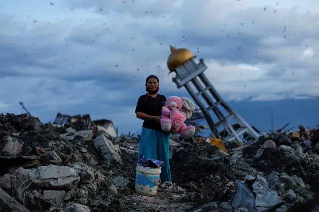A woman holds a stuffed rabbit toy after it was found at her destroyed home where she said she had lost her three children, in Palu, Central Sulawesi, Indonesia, October 7, 2018. (Photo by Jorge Silva/Reuters)