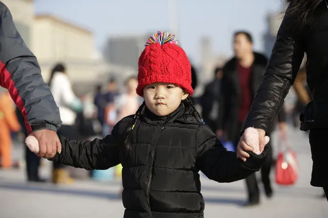 A six-year-old girl walks with her mother and grandfather as they arrive at Beijing Railway Station for Spring Festival, China, January 25, 2016. (Photo by Jason Lee/Reuters)