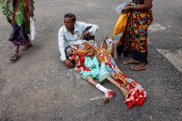 A man holds his mother, Sayyanbai Ikkurwar, as they wait for a stretcher at the Shankarrao Chavan Government Medical College and Hospital in Nanded, India on October 4, 2023. (Photo by Francis Mascarenhas/Reuters)