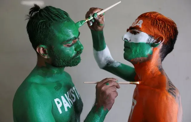 Cricket fans, Arun Haryani (Right) and Anil Advani (Left) paint their bodies in the Indian and Pakistani national flag colours, ahead of the match between India and Pakistan in the ICC World Cup, in Ahmedabad, India on October 11, 2023. (Photo by Amit Dave/Reuters)