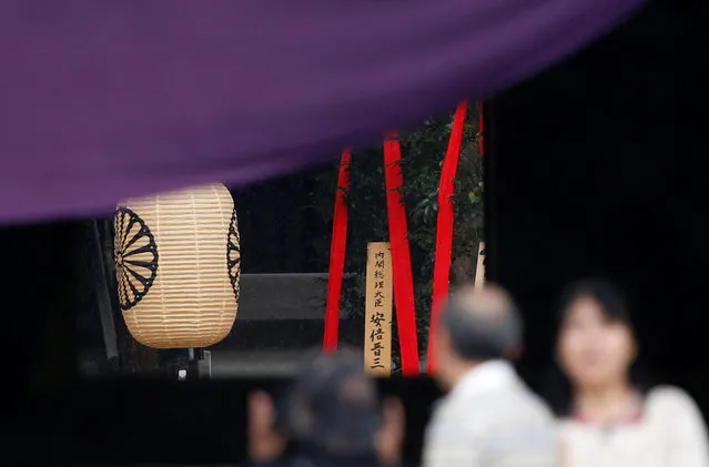 A wooden sign which reads “Prime Minister Shinzo Abe” is seen on a ritual offering, a masakaki tree, from Abe to the Yasukuni Shrine, inside the main shrine as visitors pray at the controversial shrine for war dead in Tokyo, Japan, October 17, 2016. (Photo by Toru Hanai/Reuters)