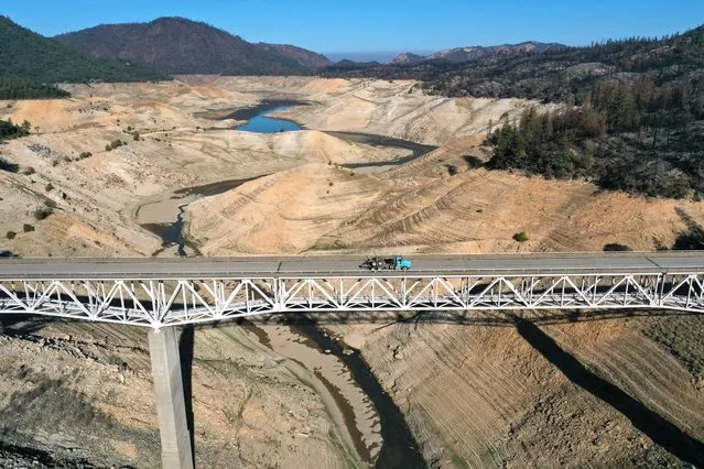 In an aerial view, the Enterprise Bridge crosses over a section of Lake Oroville that was previously underwater on July 22, 2021 in Oroville, California. As the extreme drought emergency continues in California, Lake Oroville's water levels are continuing to drop to 28 percent of capacity. State water officials say that Lake Oroville's Edward Hyatt Powerplant might be forced to shut down the hydroelectric plant as soon as August or September if water levels continue to drop. (Photo by Justin Sullivan/Getty Images)