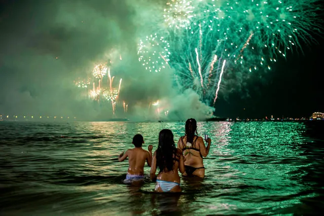People watch fireworks from the water on Copacabana beach in Rio de Janeiro, Brazil, during the New Year celebration on January 1, 2019. (Photo by Daniel Ramalho/AFP Photo)