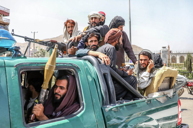 Taliban fighters are seen on the back of a vehicle in Kabul, Afghanistan, 16 August 2021. Taliban co-founder Abdul Ghani Baradar, on 16 August 2021, declared victory and an end to the decades-long war in Afghanistan, a day after the insurgents entered Kabul to take control of the country. Baradar, who heads the Taliban political office in Qatar, released a short video message after President Ashraf Ghani fled and conceded that the insurgents had won the 20-year war. (Photo by EPA/EFE/Rex Features/Shutterstock/Stringer)