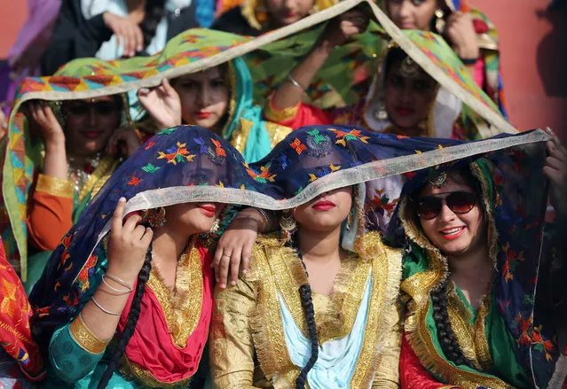 Indian women, wearing traditional Punjabi attire, cover themselves against sunshine as they wait before their performance during the full and final dress rehearsal for India's Republic Day celebrations and parade in Amritsar, India, 24 January 2019. Republic Day of India marks the adoption of the constitution of India and the transition of the country from British rule to a republic on 26 January 1950. (Photo by Raminder Pal Singh/EPA/EFE)
