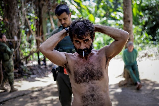 Members of the Special Inspection Group from the Brazilian Institute of Environment and Renewable Natural Resources (IBAMA) detain an illegal miner during an operation against illegal mining in Yanomami Indigenous land, Roraima state, Brazil, on December 5, 2023. (Photo by Ueslei Marcelino/Reuters)