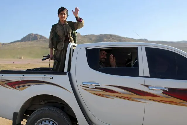 Kurdistan Workers Party (PKK) fighters wave goodbye as they leave after a visit from another base, in Sinjar, March 10, 2015. (Photo by Asmaa Waguih/Reuters)