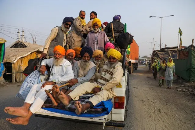 Farmers travel in a vehicle as they return back from Punjab state to attend the first anniversary of farmers' protests, on the outskirts of Delhi at Pakora Chowk near Tikri border, India, November 25, 2021. (Photo by Anushree Fadnavis/Reuters)