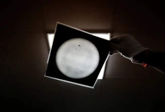 A technician holds the photographic film plate with observational data inside the archival digitisation lab at the Kodaikanal Solar Observatory, India, February 3, 2017. (Photo by Danish Siddiqui/Reuters)