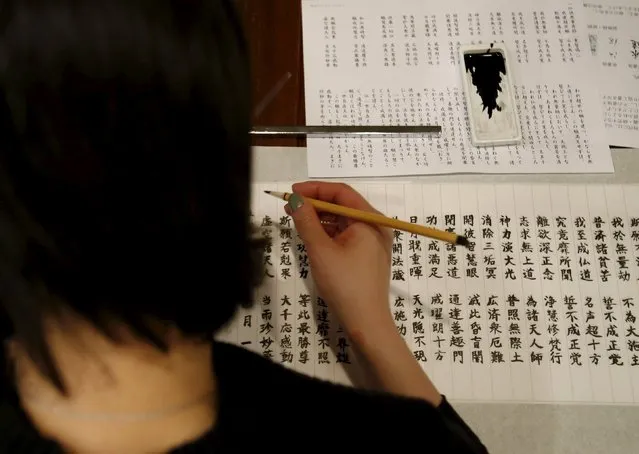A visitor traces Buddhist sutras with a brush at Tera Cafe in Tokyo, Japan, April 1, 2016. (Photo by Yuya Shino/Reuters)
