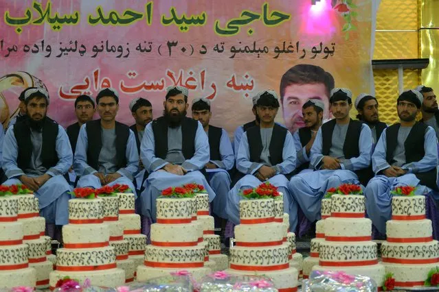Grooms sit inside a wedding hall as they wait for the start of a mass marriage ceremony organised by the Selab Charity Foundation in Kandahar on December 16, 2021. (Photo by Javed Tanveer/AFP Photo)
