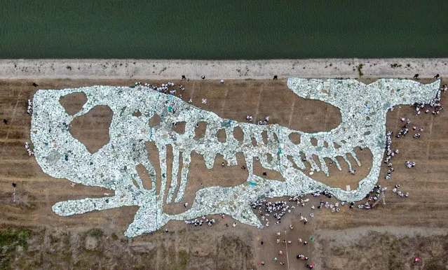 This aerial photo taken on June 10, 2019 shows a 68-metre long image of a whale formed by plastic waste collected from the ocean during an event to raise awareness on ocean conservation at Rudong Yangkou Harbour in Nantong in China's eastern Jiangsu province. (Photo by AFP Photo/China Stringer Network)