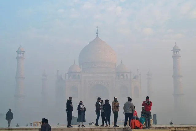 Tourists visit the Taj Mahal amidst fog in Agra on January 4, 2022. (Photo by Pawan Sharma/AFP Photo)