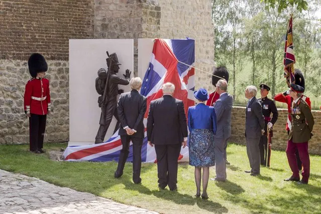 Britain's Prince Charles (4thL) holds a rope as he unveils a monument during a ceremony for the opening of the Hougoumont farm as part of the bicentennial celebrations for the Battle of Waterloo, near Waterloo, Belgium June 17, 2015. The commemorations for the 200th anniversary of the Battle of Waterloo will take place in Belgium on June 19 and 20. REUTERS/Geert Vanden Wijngaert/Pool