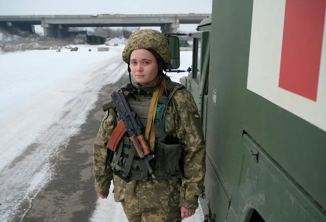 Nastya, 21, a medic of the Ukrainian armed forces, stands next to a military ambulance near the line of separation from Russian-backed rebels outside a village of Pisky in Donetsk Region, Ukraine on January 26, 2022. (Photo by Maksim Levin/Reuters)