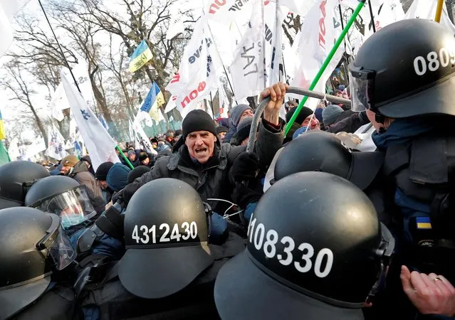Demonstrators scuffle with Ukrainian law enforcement officers during a rally of entrepreneurs and representatives of small businesses who demand government support, in front of the parliament building in Kyiv, Ukraine on January 25, 2022. (Photo by Serhii Nuzhnenko/Reuters)