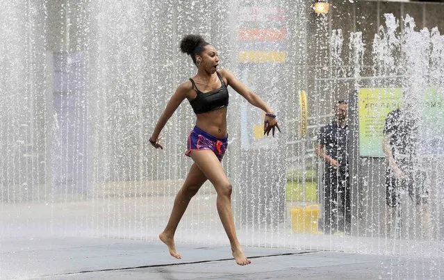 A young woman plays in a fountain on a hot Summer day in London, Britain July 1, 2015. (Photo by Paul Hackett/Reuters)
