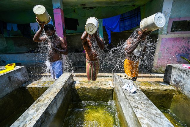 Men bathe at a public well on a hot summer day in Colombo on April 30, 2024. (Photo by Ishara S Kodikara/AFP Photo)