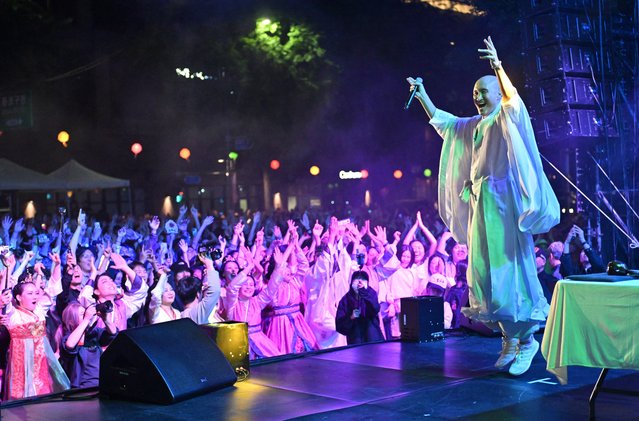 This picture taken on May 12, 2024 shows South Korean comedian Youn Sung-ho known as 'NewJeansNim' wearing monk's robes performing during an electronic dance music party (EDM) event for the annual lotus lantern festival to celebrate the upcoming Buddha's birthday in Seoul. With shaved head and flowing monk robes, a South Korean DJ chants traditional Buddhist scripture mixed with GenZ life advice over a thumping EDM beat, as the crowd goes wild. (Photo by Jung Yeon-je/AFP Photo)