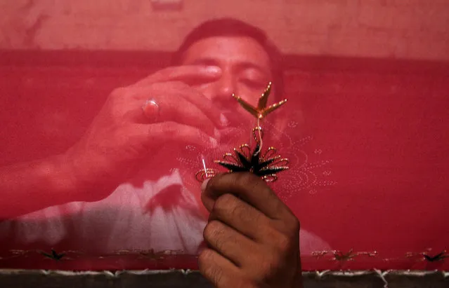 A Pakistani artisan prepares elements for a traditional costume at an embroidery shop in Karachi, Pakistan, Saturday, July 11, 2015. (Photo by Fareed Khan/AP Photo)