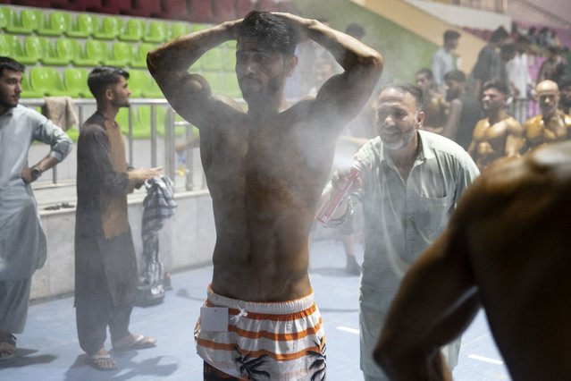 Afghan bodybuilders prepare backstage before a fitness event held by the Afghanistan Bodybuilding & Fitness Federation (AFBBF) in Kabul on July 9, 2024. (Photo by Wakil Kohsar/AFP Photo)